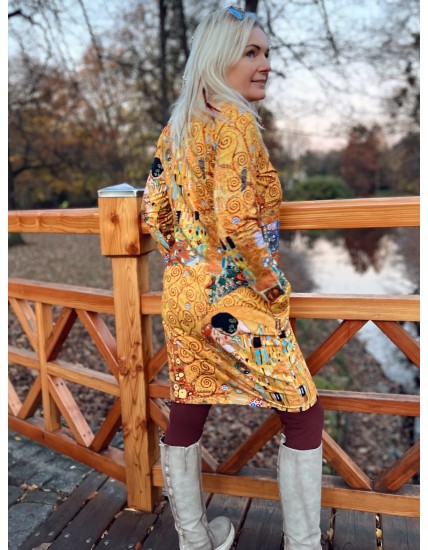 Kobieta w sukience midi z długimi rękawami i wzorami etnicznymi w jesiennych kolorach.