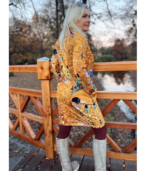 Kobieta w sukience midi z długimi rękawami i wzorami etnicznymi w jesiennych kolorach.